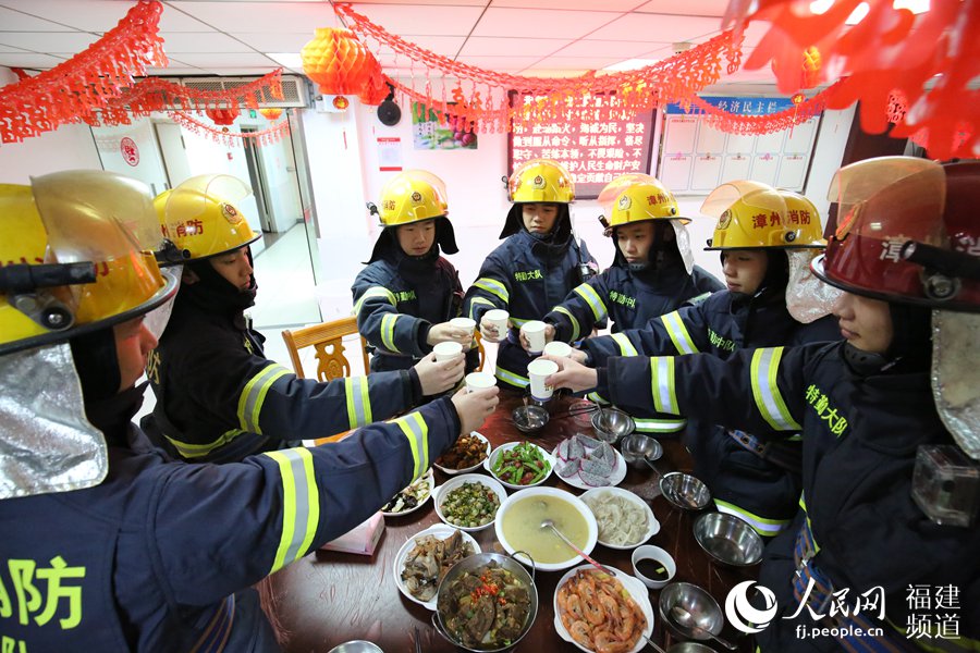 漳州消防特勤大隊一中隊消防指戰(zhàn)員歡聚一堂，吃年夜飯，舉杯共飲。