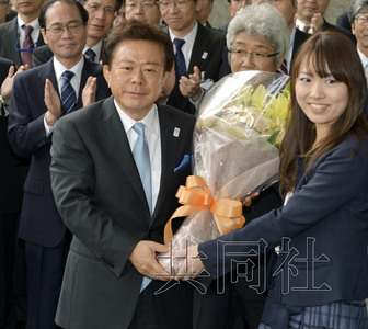 12月18日，高票當(dāng)選東京都新知事的豬瀨直樹正式到任。圖為豬瀨從政府職員手中接過花束。(共同社)