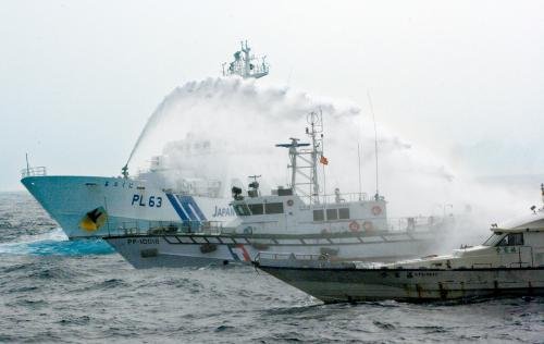 臺灣“海巡署”的巡邏船（中）在掩護保釣船“全家福”號（右）躲避日本海上保安廳巡視船的水炮攻擊。