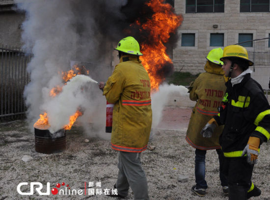 兩名志愿者在消防員的指揮下滅火。（攝影：張瑾） 