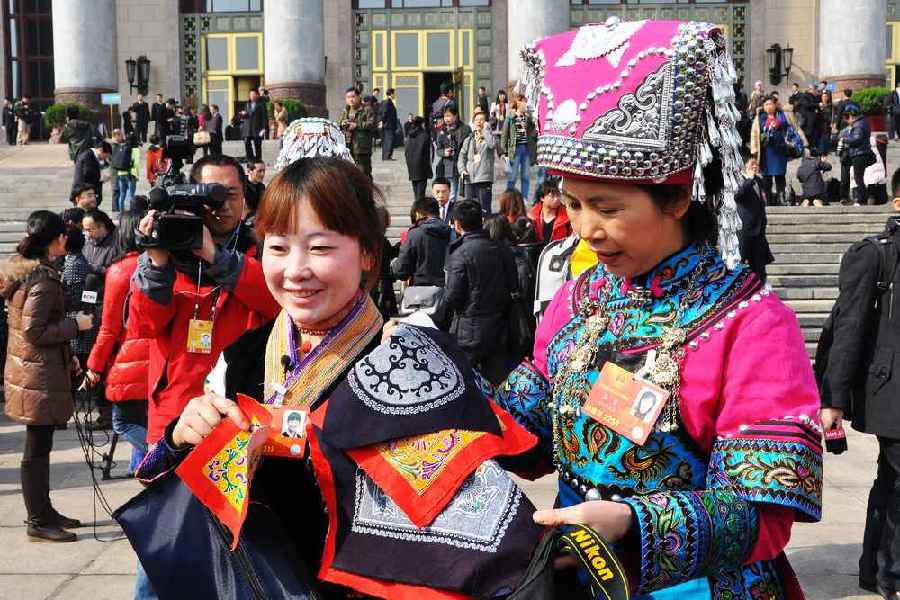 云南代表團(tuán)的兩位女代表在為記者展示她們帶來(lái)的民族特色手工藝品。 人民網(wǎng)記者 馬麗婭 攝