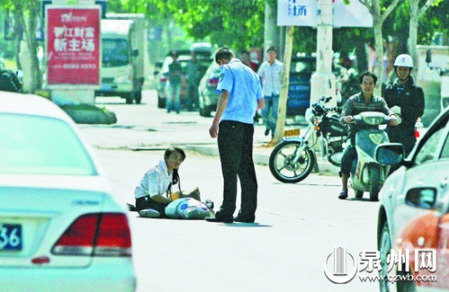 女孩從摩的上摔下，跌坐路中央，恰遇社區(qū)聯(lián)防巡邏人員扶起。