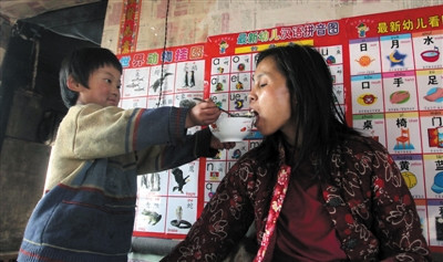 小孫悅為臥床的母親喂飯。