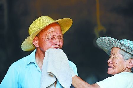 妻子黃茹杰正給丈夫雷卓禮擦汗水 　　本組圖片由記者 張路橋 實(shí)習(xí)生 程雯麗 攝