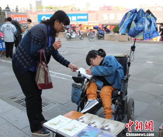 洛洛正在給買書的顧客簽名。 馮曉林 攝